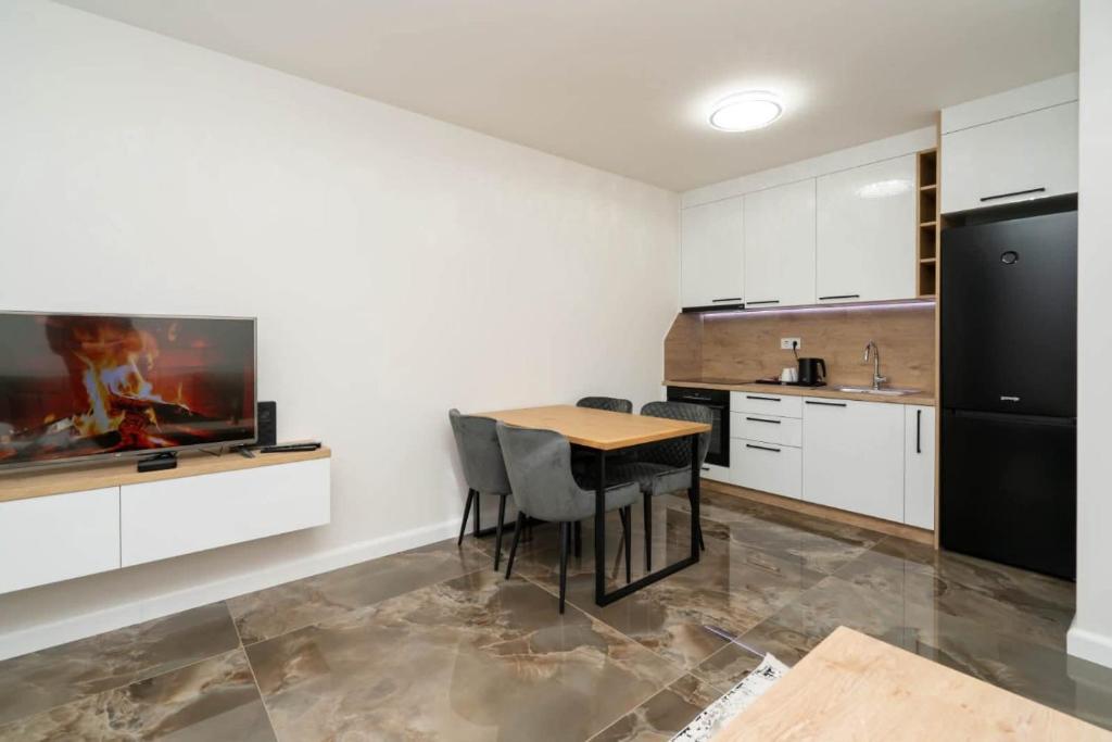 Kuhinja i trpezarijski sto u apartmanu, s pećnicom i frižiderom pune visine