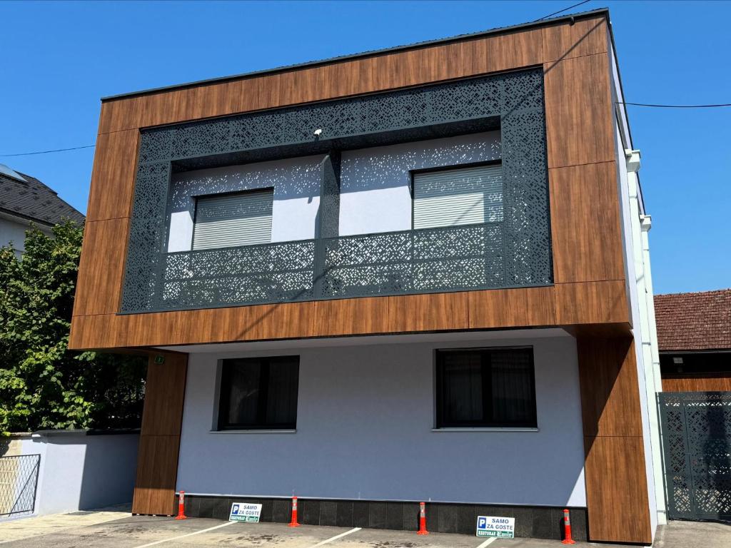 Zgrada Apartmana Deluxe s drvenom fasadom i označenim parkingom za goste