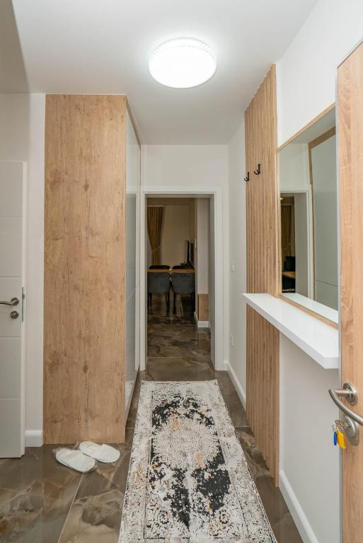 Ulazni hodnik apartmana s ugradbenim ormarom, ogledalom i mramornim podom